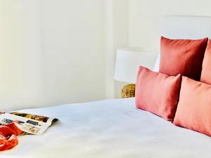 een bed met rode kussens en een tijdschrift erop bij Canaryislandshost l Room in Playa Blanca