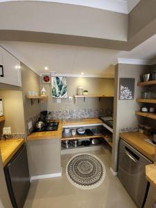 a large kitchen with a stove and a rug at Flamant Self-Catering Apartment in Velddrif