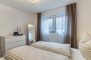Schlafzimmer mit einem Bett, einer Kommode und einem Spiegel in der Unterkunft Casa di Michelle in Ringsheim