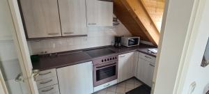 a small kitchen with white cabinets and a microwave at Apartment am Ammersee in Herrsching am Ammersee