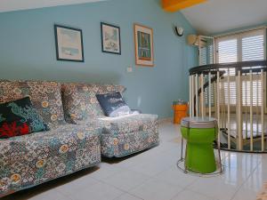 ein Wohnzimmer mit einem Sofa und einem Kinderbett in der Unterkunft Mirone Apartment FRONTE MARE beachfront house in Roccalumera