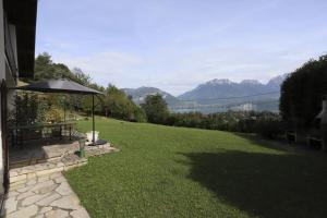 a lawn with a picnic table and an umbrella at Les Eaux Vives in Sévrier