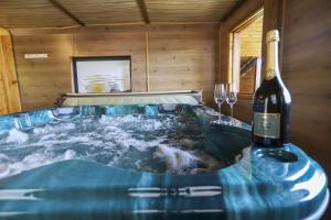 uma garrafa de vinho ao lado de uma banheira em Les Eaux Vives em Sévrier
