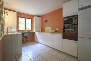 a kitchen with white cabinets and a sink at Les Eaux Vives in Sévrier