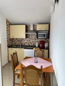 a small kitchen with a table and chairs at Apartmani Mužić in Orlec