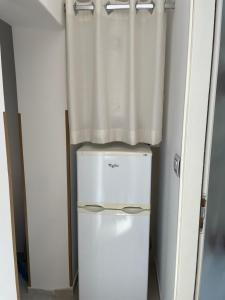 a refrigerator in a room with a curtain at Apartmani Mužić in Orlec