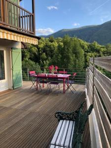 a patio with a table and chairs on a deck at Charming cottage, 10 minutes from Ax les Thermes in Unac