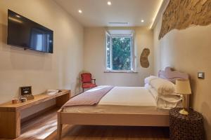 a bedroom with a bed and a tv on the wall at Croce di mezzo in Montalcino