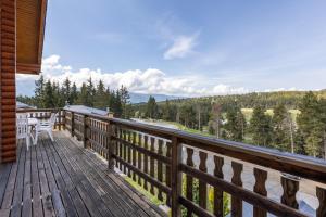 a wooden deck with a table and chairs on it at Chalet les deux marmottes - Vue montagne in Bolquere Pyrenees 2000