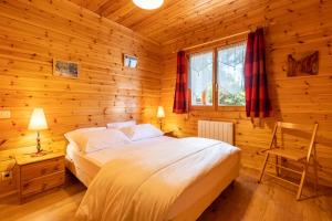 a bedroom with a bed in a wooden cabin at Chalet les deux marmottes - Vue montagne in Bolquere Pyrenees 2000