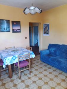 ein Wohnzimmer mit einem Tisch und einem blauen Sofa in der Unterkunft Gli Aristogatti in Campo Tizzoro