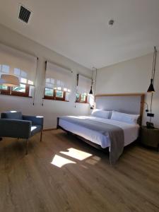 a bedroom with a large bed and a chair at Hotel El Rosal de Cudillero in Cudillero