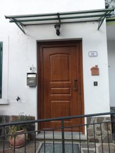 una puerta marrón en el lateral de un edificio blanco en Gli Aristogatti en Campo Tizzoro
