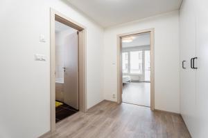 ein leeres Zimmer mit einer Tür und einem Spiegel in der Unterkunft AuriApartments Libeň nový byt 1kk s garáží in Prag