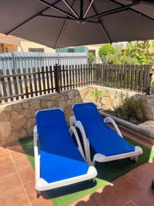 two blue chairs on a patio under an umbrella at Bungalow near Yumbo in Playa del Ingles