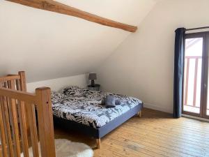 1 dormitorio con 1 cama en una habitación con ventana en La petite maison solognote, en La Ferté-Saint-Aubin
