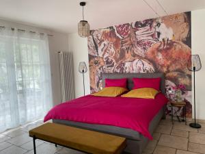 a bedroom with a large pink bed with a painting on the wall at Ferienwohnung Berens in Cochem