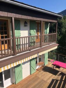 a house with a deck with a pink bench on it at Charming cottage, 10 minutes from Ax les Thermes in Unac