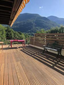 a bench sitting on a wooden deck with a table at Charming cottage, 10 minutes from Ax les Thermes in Unac