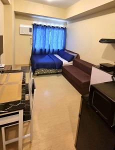 a small living room with a couch and a window at Fully furnishd Avida condo 2(wi-fi netflx disney+) in Cagayan de Oro