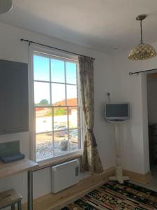 a living room with a window and a television at Norfolk broads. Vault apartment in Stalham