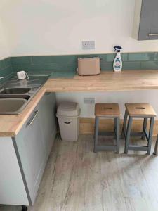 a kitchen with a counter and a sink and stool at Norfolk broads. Vault apartment in Stalham
