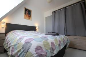 a bedroom with a bed with a colorful comforter at PEBE ART - COLMAR City center in Colmar