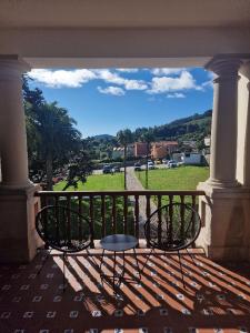 a patio with two chairs and a table on a balcony at Hotel El Rosal de Cudillero in Cudillero
