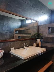 y baño con lavabo y espejo. en Junior Family Room by 233Poshtel en Lampang