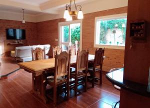 uma sala de jantar com uma mesa de madeira e cadeiras em Chalet Rustico da Elena com Sauna y Jacuzzi Unicep em São Carlos