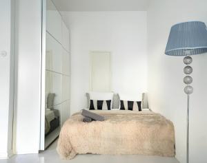 a bedroom with a bed with a blue lamp at Stylish Studio at the Heart of Helsinki in Helsinki