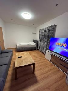 ein Wohnzimmer mit einem Sofa und einem Flachbild-TV in der Unterkunft Hotel Restaurant Rhodos in Elsterwerda