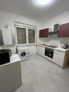 a kitchen with white cabinets and a washer and dryer at Hotel Restaurant Rhodos in Elsterwerda