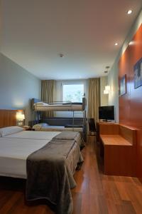 Hotel AG Express Elche في توريلانو: غرفة نوم بسريرين ومكتب وتلفزيون