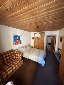 1 dormitorio con 1 cama y 1 sofá en Casa Lalla affittasi nel centro di Poschiavo, en Poschiavo