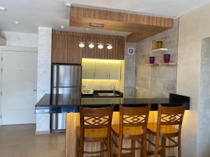 a kitchen with a black counter and wooden chairs at Il monte galala in Ain Sokhna