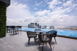 a patio with chairs and tables and a view of a pool at SF HOTEL Penthouse Residences in Phnom Penh
