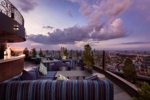 a rooftop patio with couches and a view of a city at SF HOTEL Penthouse Residences in Phnom Penh