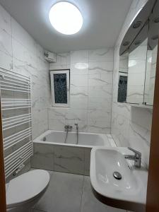 a bathroom with a tub and a sink and a toilet at Hotel Restaurant Rhodos in Elsterwerda