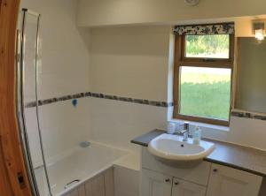 a bathroom with a sink and a shower at Spacious Luxury barn conversion - next to Tarka Trail cycle path in Great Torrington