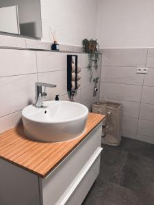 a bathroom with a white sink on a wooden counter at Bergoase Relax&Spa in Unteropfingen