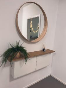 a mirror on a wall above a white dresser at Bergoase Relax&Spa in Unteropfingen