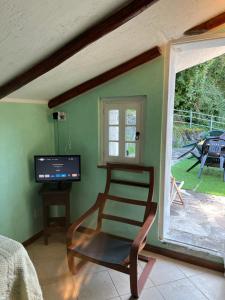 a room with a chair and a television and a window at Camera Singola con Terrazza Panoramica in Serina