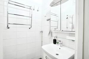 Baño blanco con lavabo y espejo en Stylish Studio at the Heart of Helsinki, en Helsinki