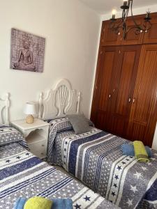 Un dormitorio con dos camas y una cómoda. en Apartamento Plata Real, en Sanlúcar de Barrameda