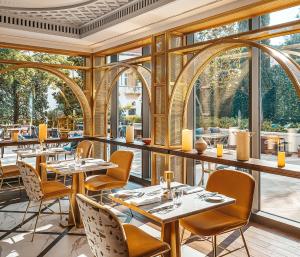 a restaurant with tables and chairs and large windows at Hilton Imperial Dubrovnik in Dubrovnik
