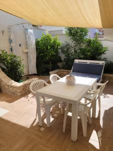 普爾薩諾的住宿－Locazione turistica Le Vele，庭院里的白色桌椅