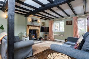 a living room with blue couches and a fireplace at Hurdler's Cottage in Shipston-on-Stour