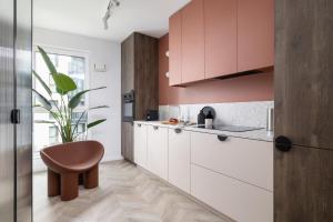 cocina con armarios blancos y taburete marrón en Deluxe Apartment Podskale 18 with Parking & Balcony in Kraków by Renters Prestige en Cracovia