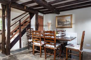 comedor con mesa de madera y sillas en Hurdler's Cottage, en Shipston on Stour